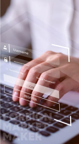 Two hands typing on a laptop, with a username & password being typed in.